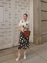 a lady wears a jacquard v-neck knit top with floral printed skirt